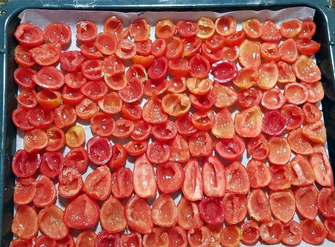 Backblech mit Backpapier und den ausgelösten Tomaten
